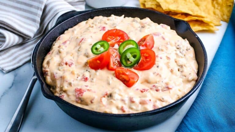 Cheesy sausage dip in a skillet with tortilla chips.