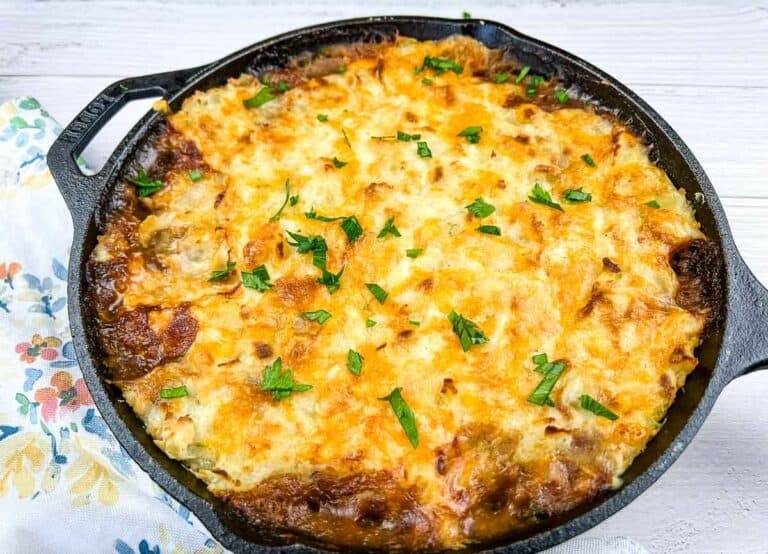 A dinner in a dish full of cheesy casserole in a floral pattern.