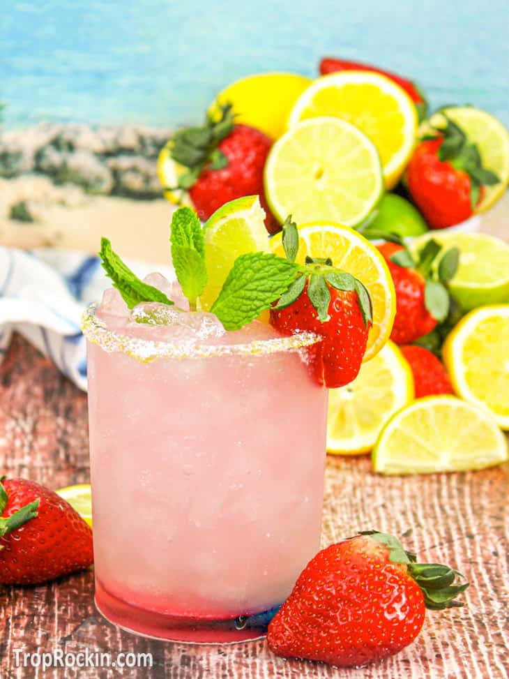 A tequila-infused strawberry margarita with fresh mint leaves and juicy strawberries.