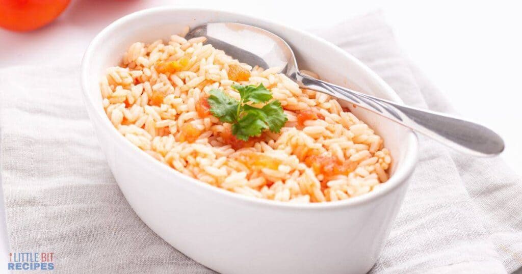 Mexican rice in small oval serving dish with spoon.