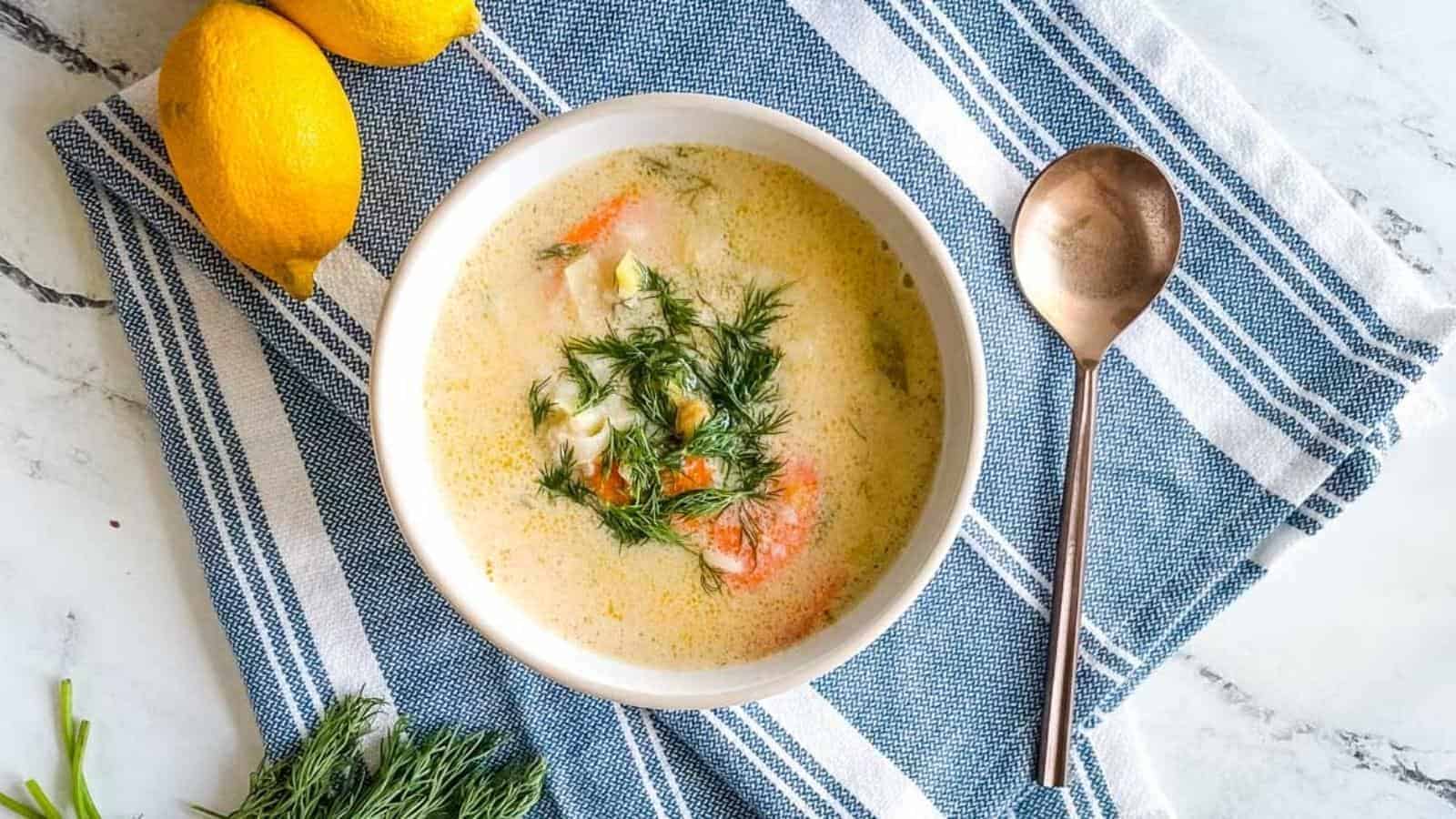 A bowl of soup with lemons and dill.