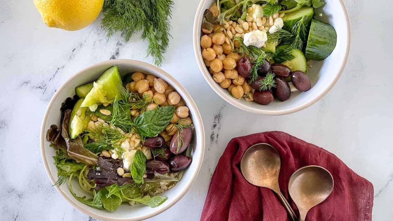 Two bowls with olives, chickpeas and lemons.