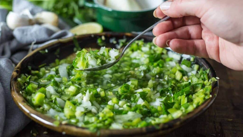 Side view of hand lifting a spoon of aji.