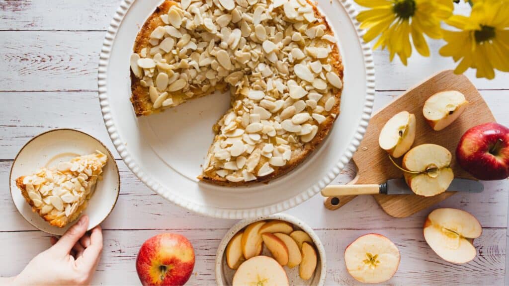 A slice of apple cake on a plate with apples on it.