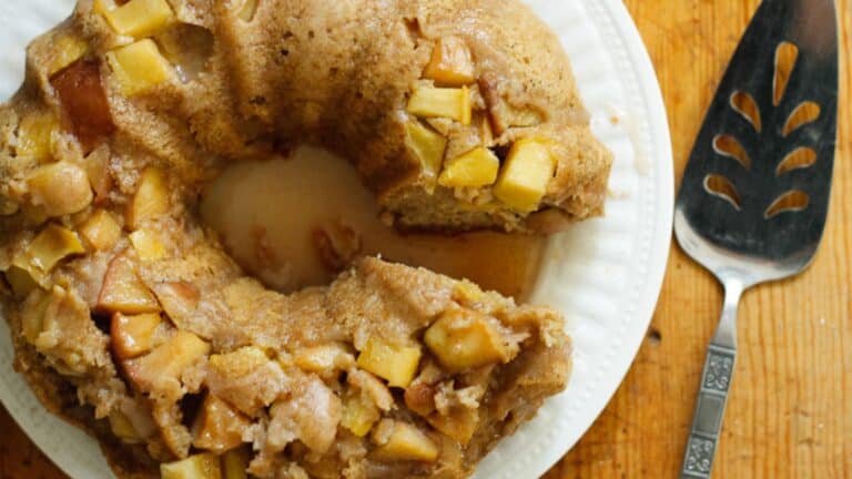 A bundt cake on a plate with a bite taken out of it.