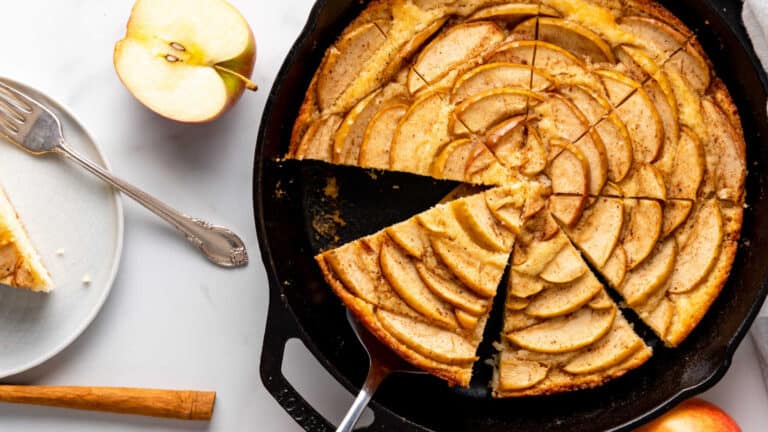 A slice of apple pie in a cast iron skillet.