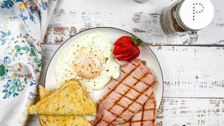 A plate with ham, eggs and toast.