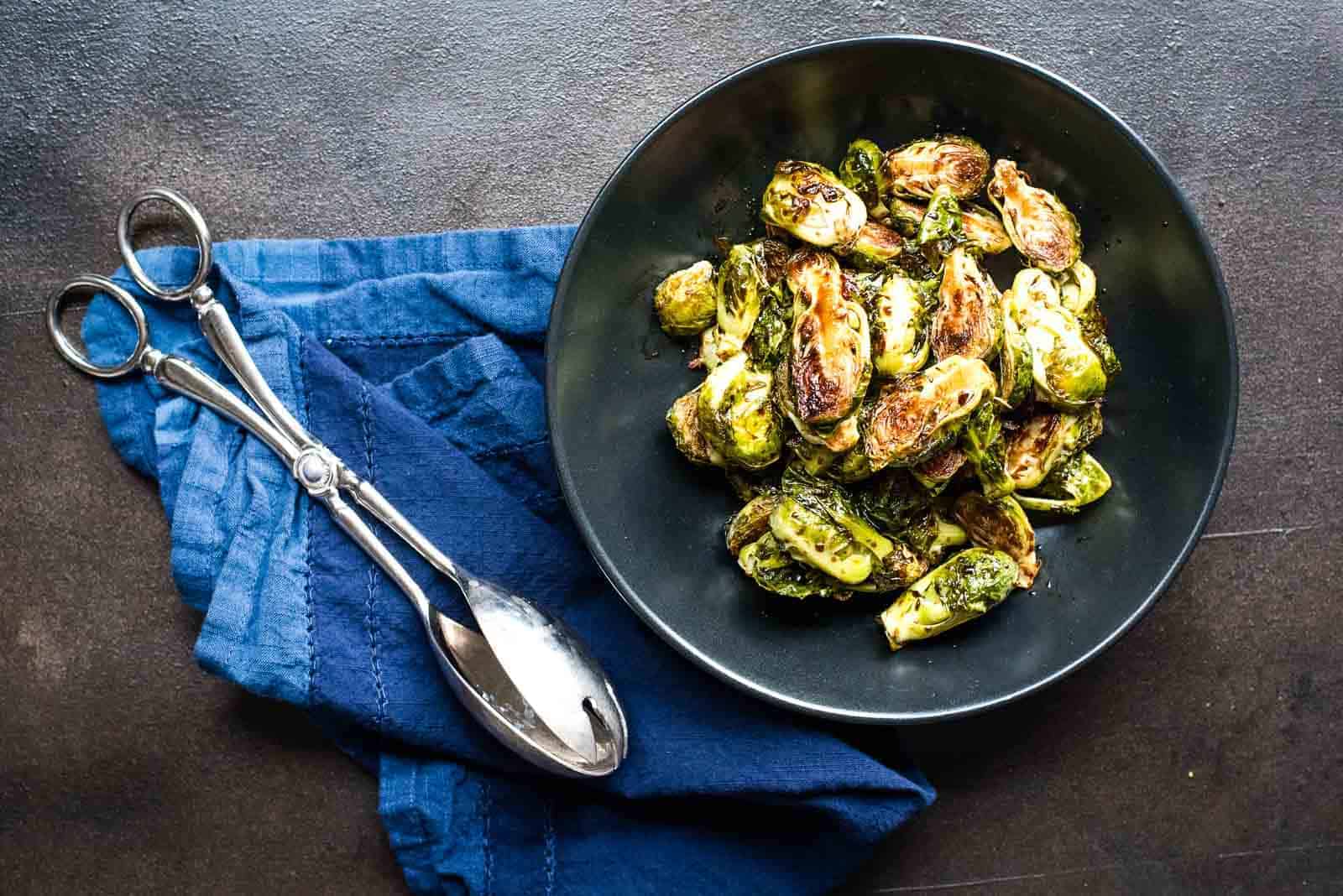 Roasted balsamic glazed brussels sprouts in a black bowl.