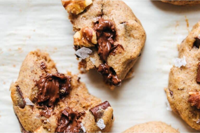 A group of cookies with chocolate and walnuts on top.