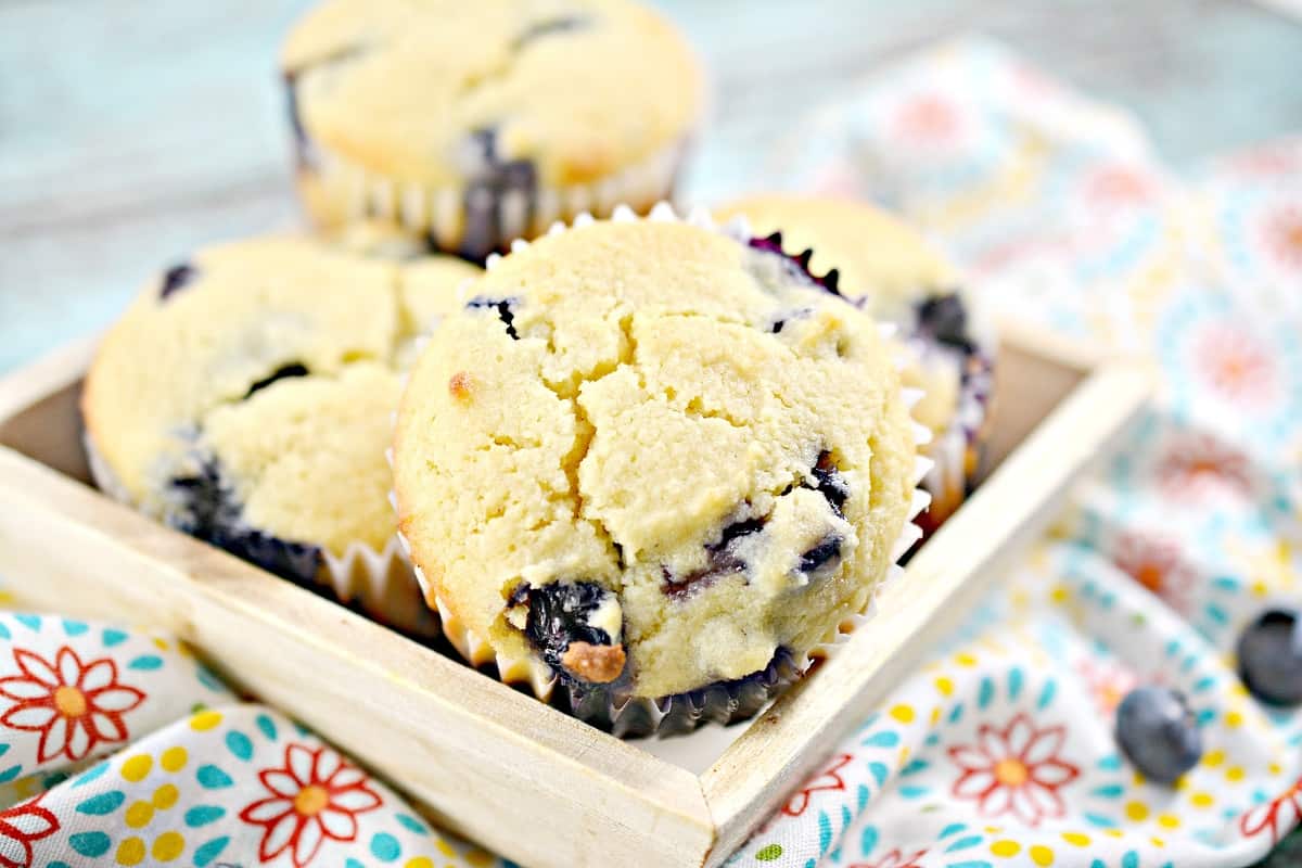 Blueberry muffins in a wooden dish.