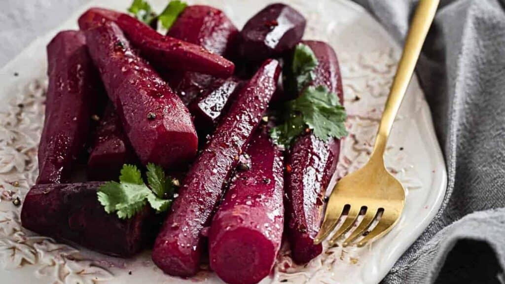 Festive holiday appetizers featuring beets on a white plate with a fork.