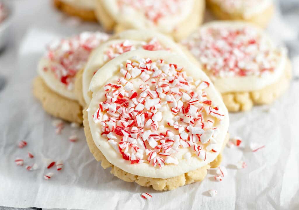 A plate of cookies with peppermint icing and sprinkles.