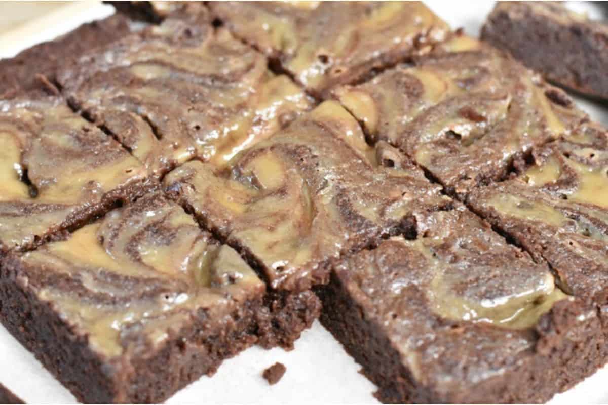 A plate of chocolate brownies with caramel swirls.