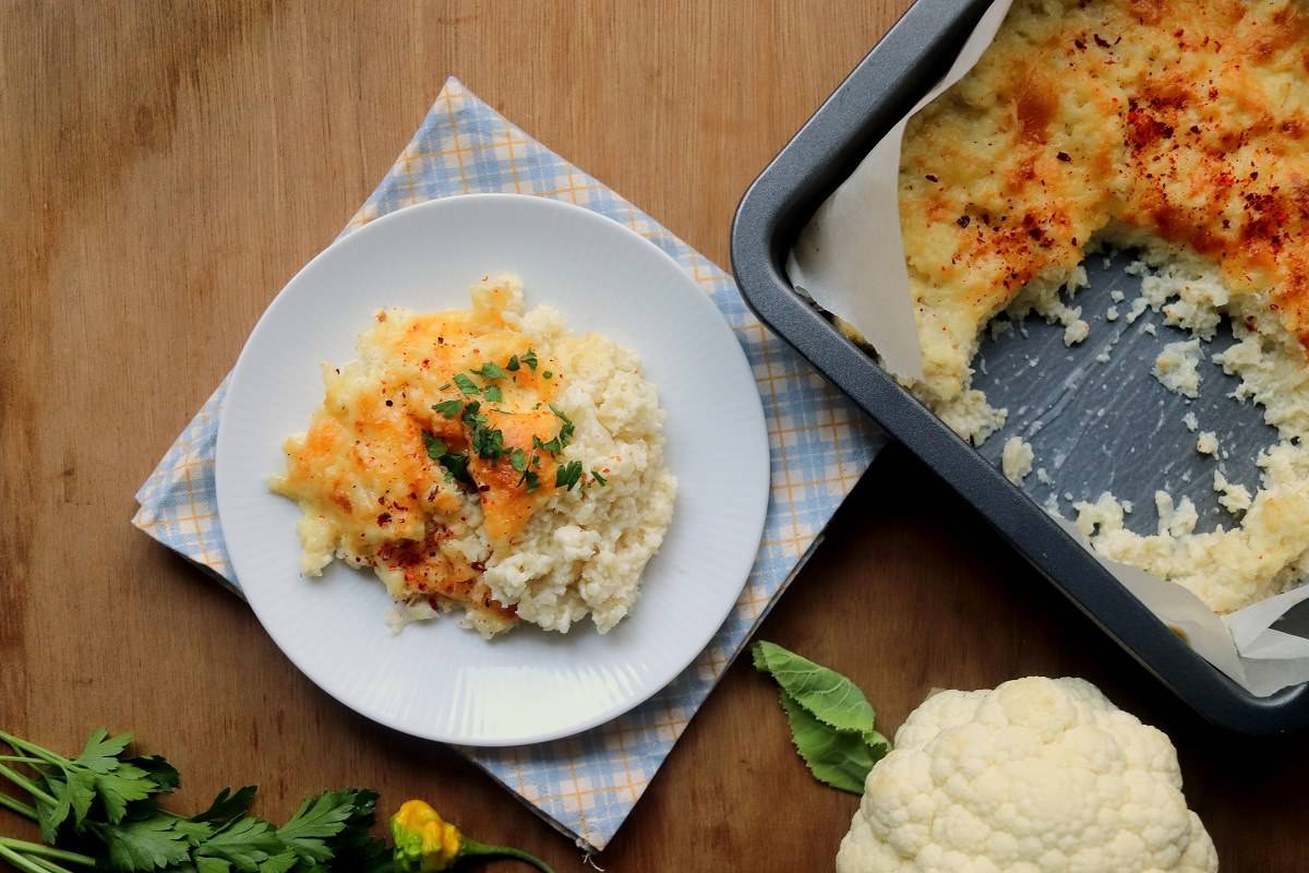 A dish with cauliflower and cheese on a wooden table.