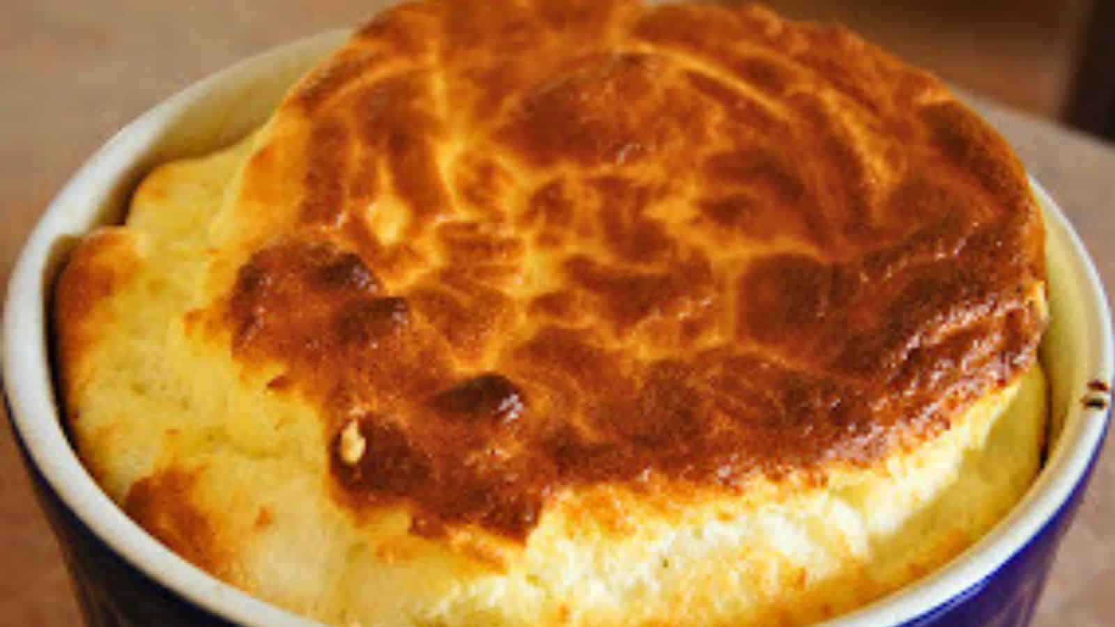 Image shows a Cheese Souffle popping out of a blue ramekin.