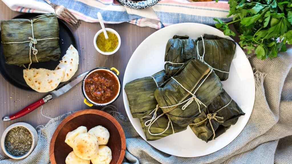 An appetizing plate of tamales and tortillas, made with an easy chicken recipe, beautifully presented on a table.