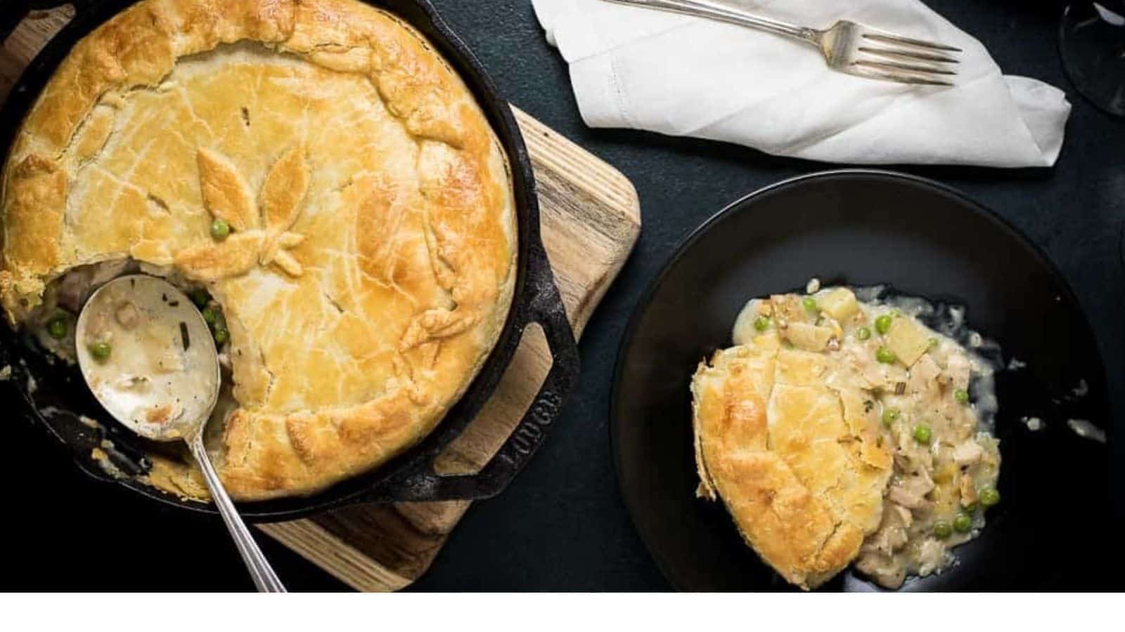 An appetizing chicken pot pie on a plate with a spoon next to it – perfect for those seeking easy chicken recipes.