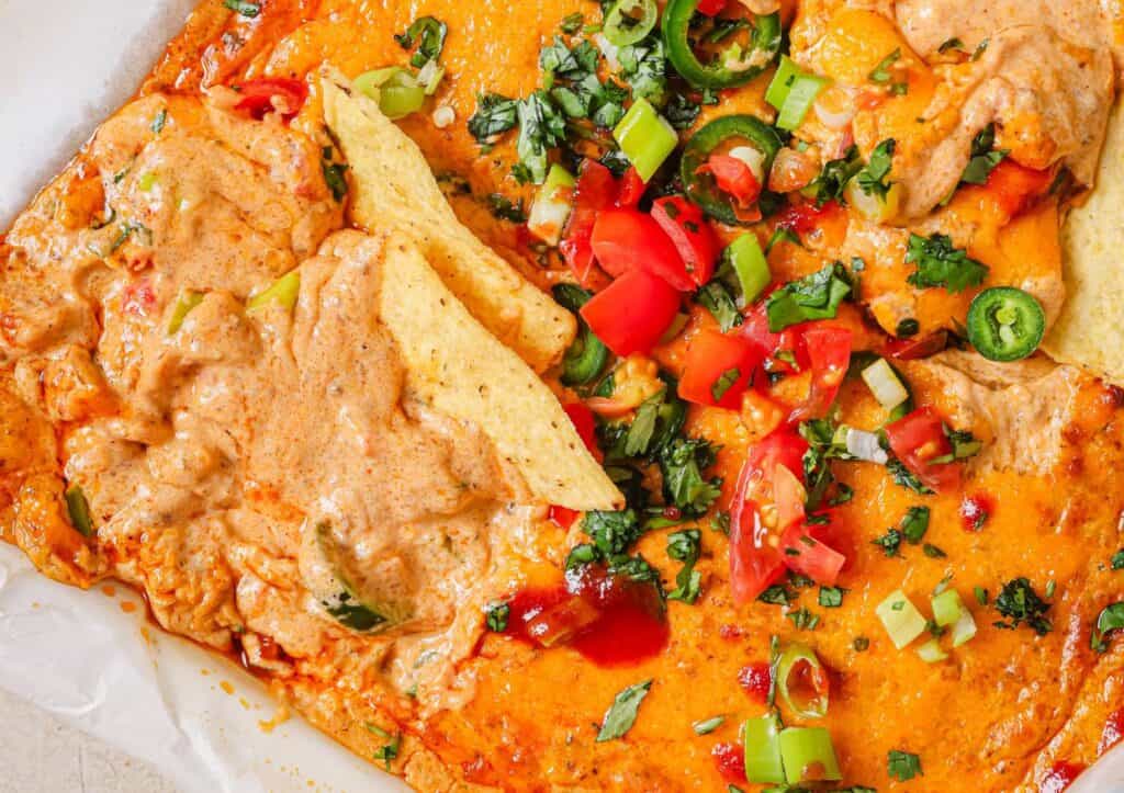 Chili cheese dip in a baking dish with tortilla chips.