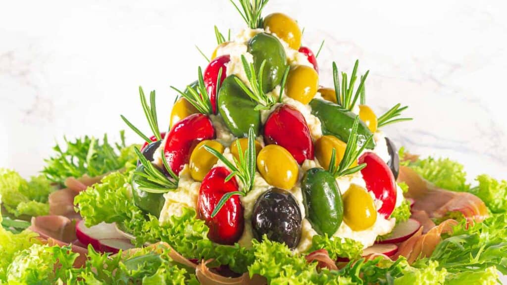 An easy breakfast christmas tree made of olives and vegetables.