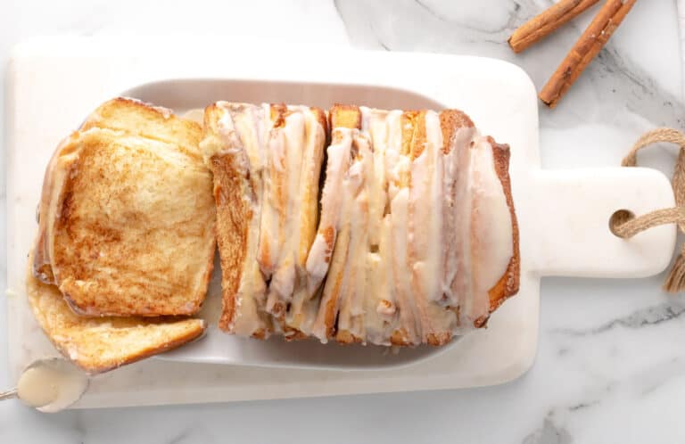 Cinnamon bread pull apart loaf on a white board.