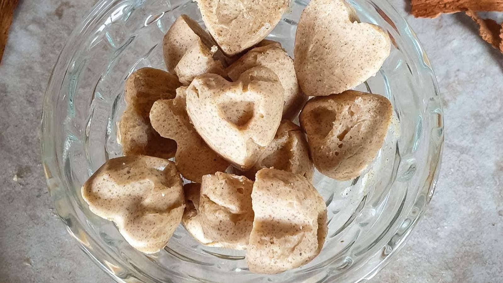 Cinnamon candies in a glass dish on stone countertop.