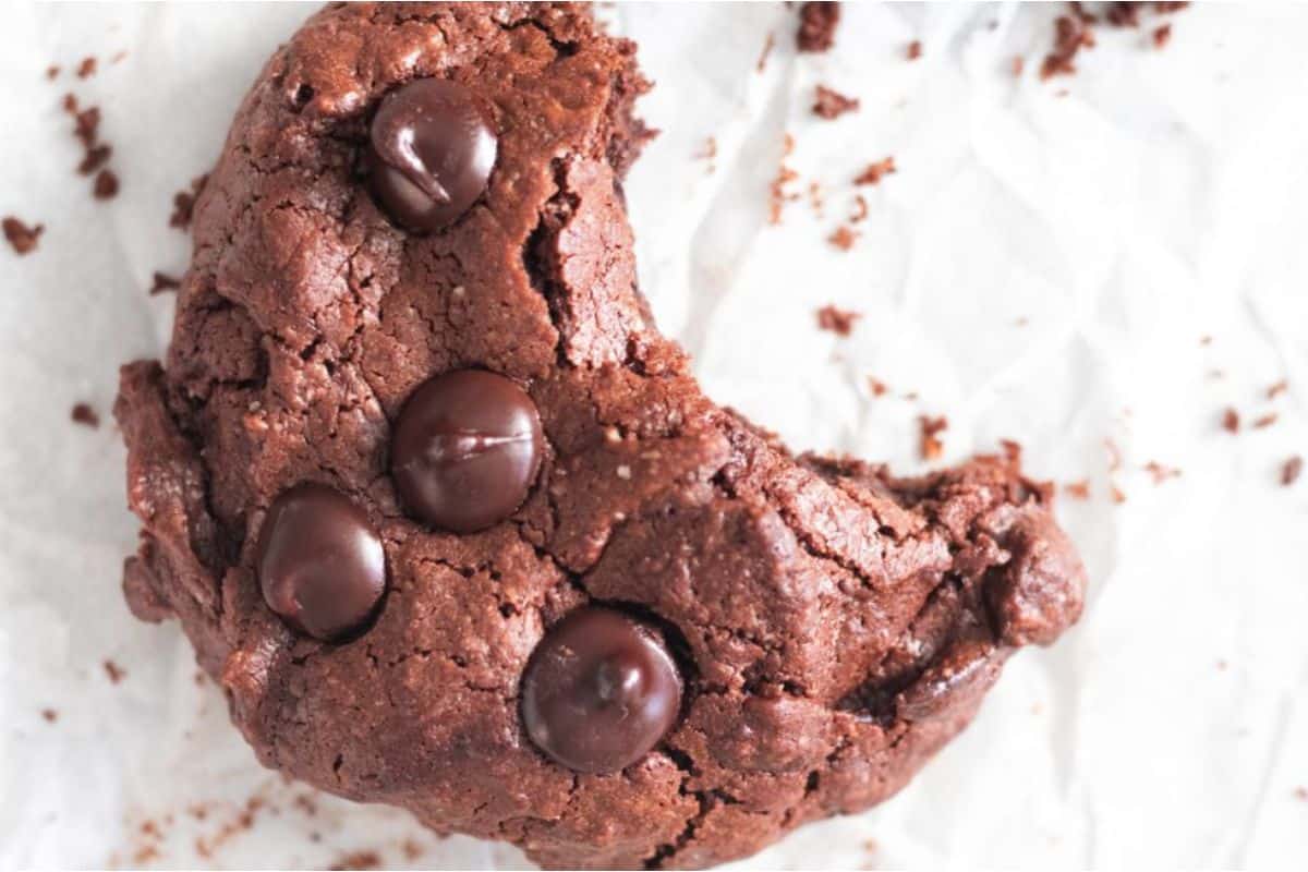 A chocolate cookie with a bite taken out of it.