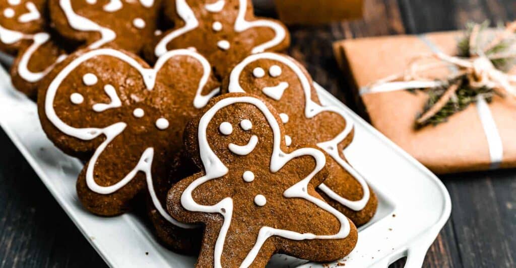 Gingerbread cookies with icing on a plate on a wooden table.