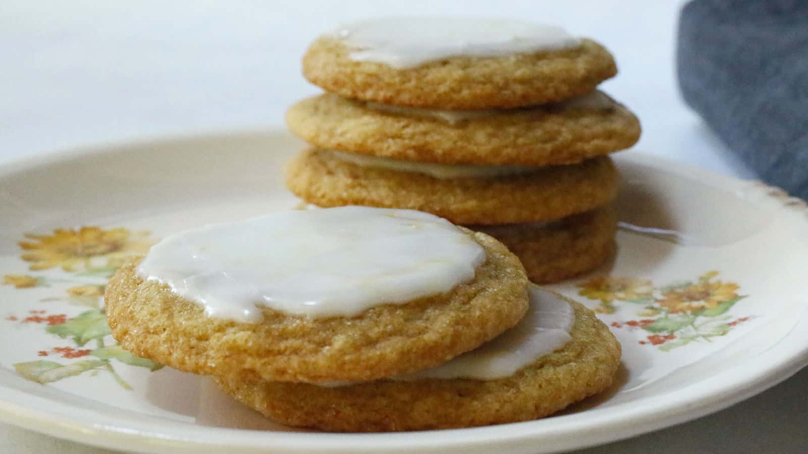 A white plate with iced lemon cookies.
