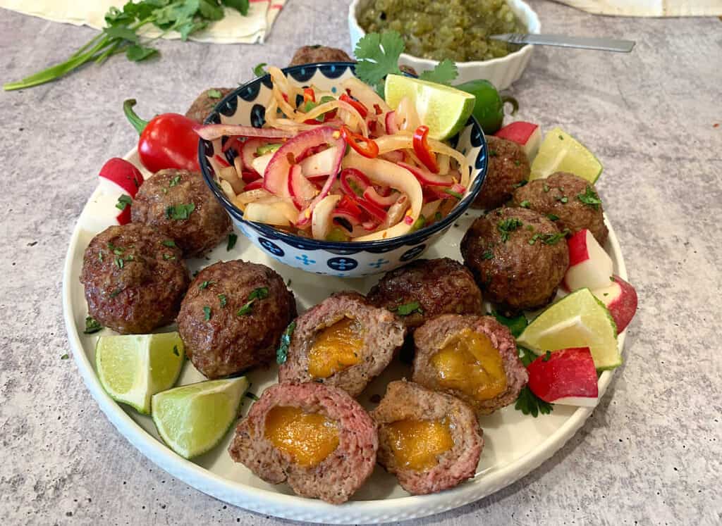 Mexican meatballs with radishes and salsa on a plate.