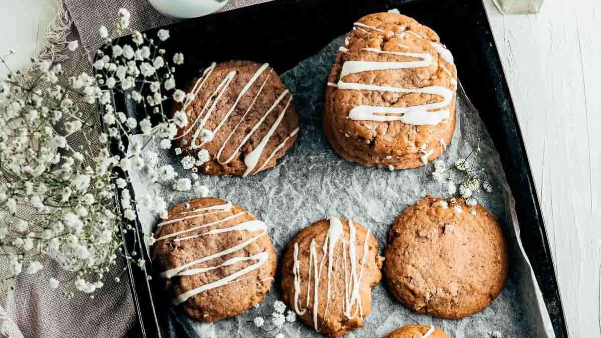 A tray of cookies with icing and flowers on it.