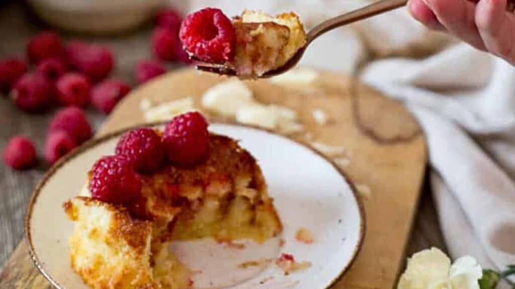 Raspberry bread pudding on a plate with a spoon.