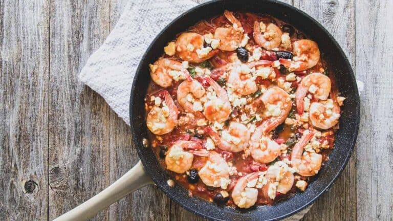 Shrimp in a skillet with tomatoes and feta cheese.