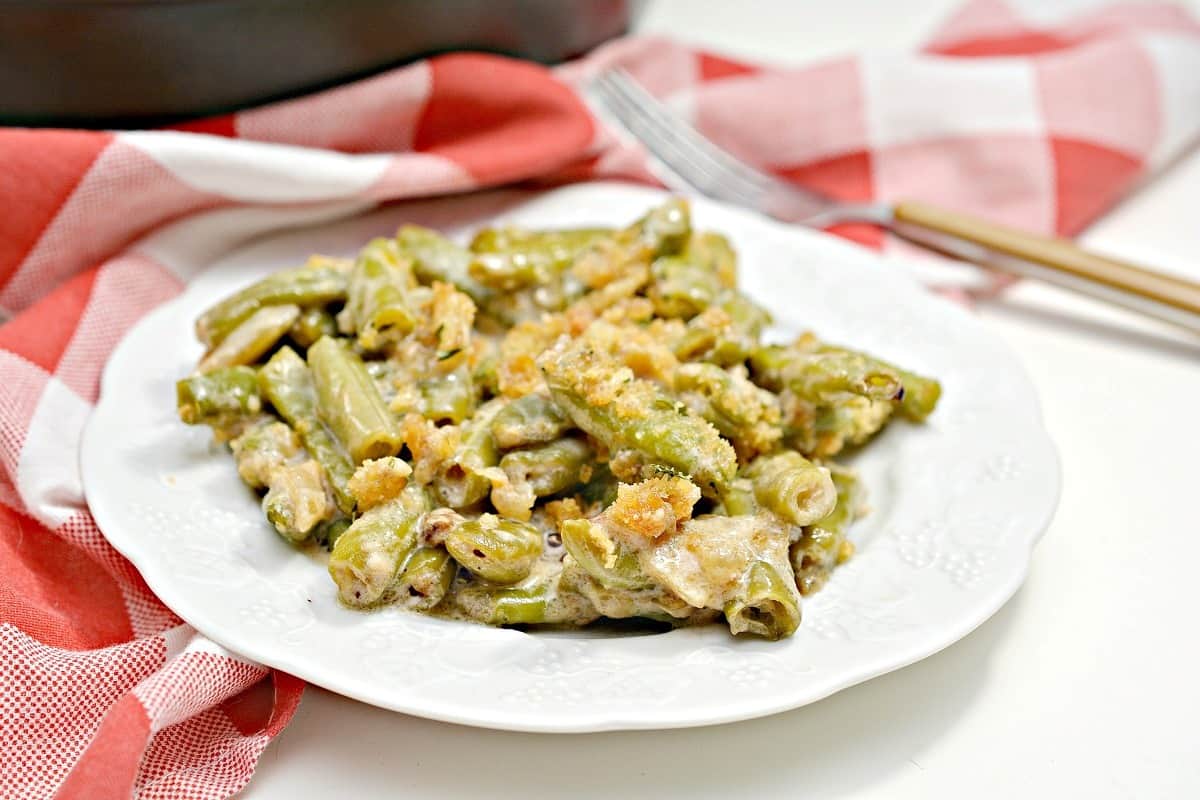 A white plate with green beans on it.