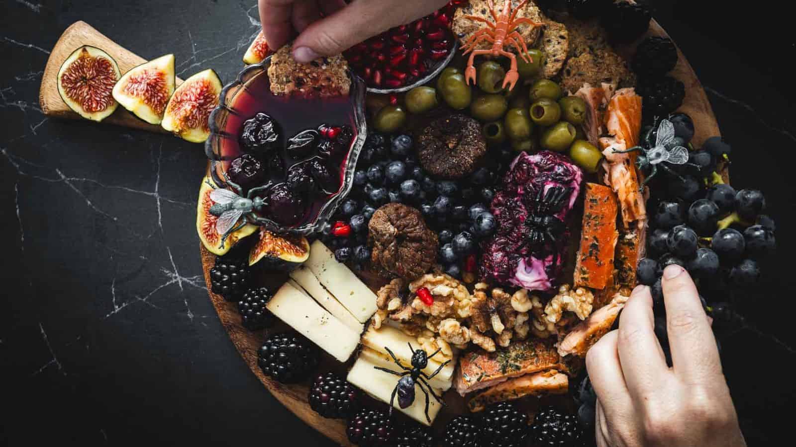 An overhead shot of halloween grazing board on a black surface.