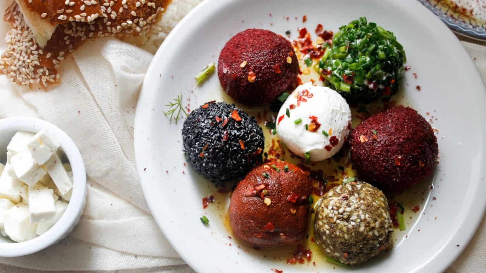 Seven labaneh balls on a plate with olive oil.