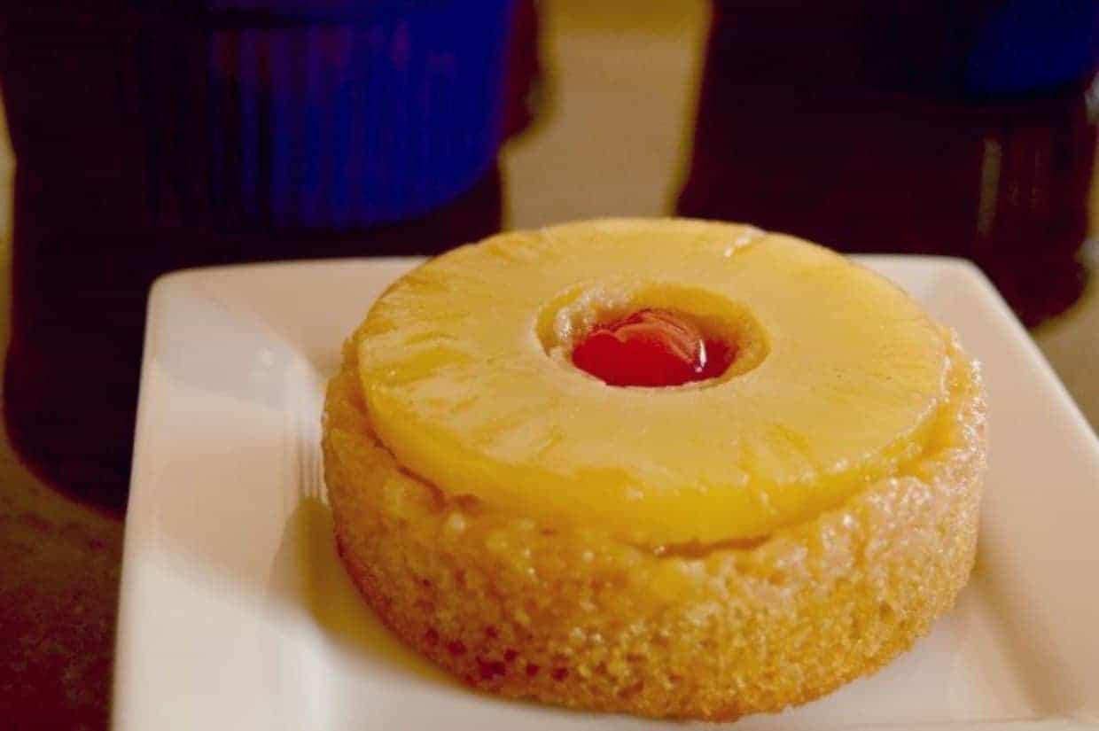 Individual pineapple upside down cake on a small white plate.