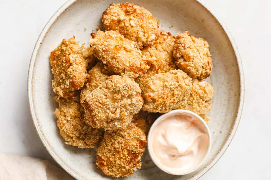 Keto chicken nuggets on a plate with dipping sauce.