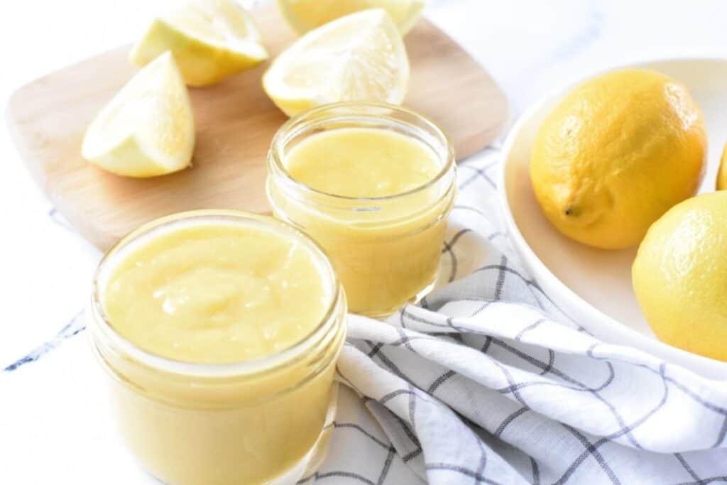 Two jars of lemon juice on a table.