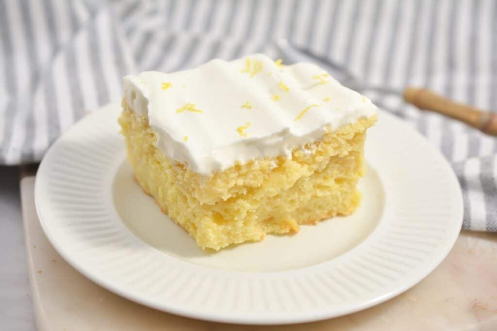 A slice of lemon cake on a white plate.