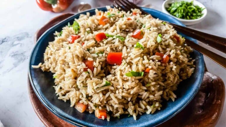 A bowl of fried rice with vegetables and a fork.