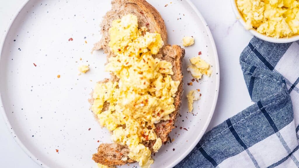 Scrambled eggs and toast on a plate.