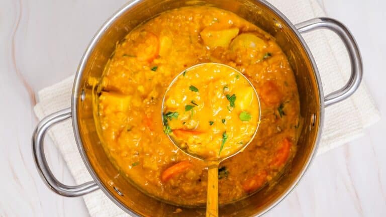 A pot of curry with a spoon in it.