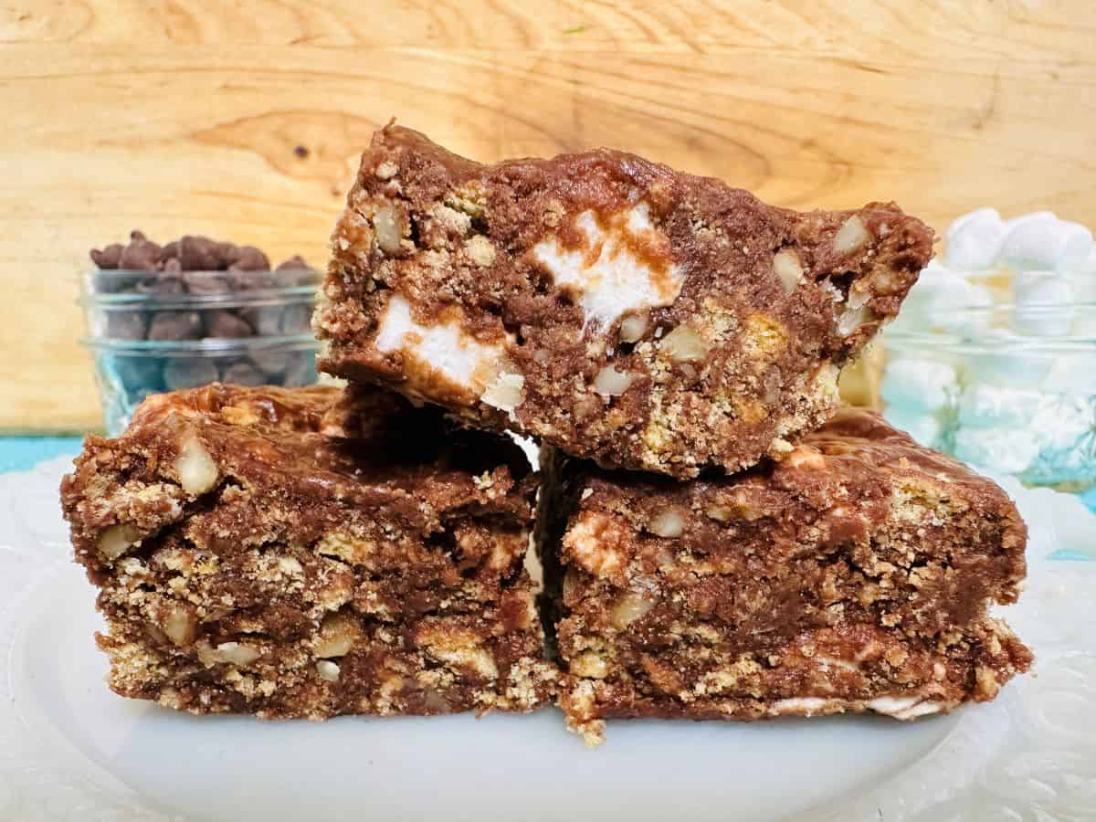 Close up side view of three no bake brownies on white plate.