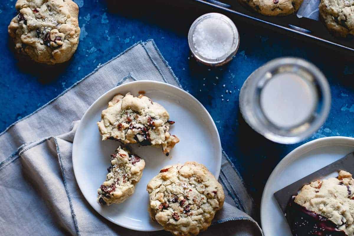 Cranberry almond chocolate chip cookies on a white plate.