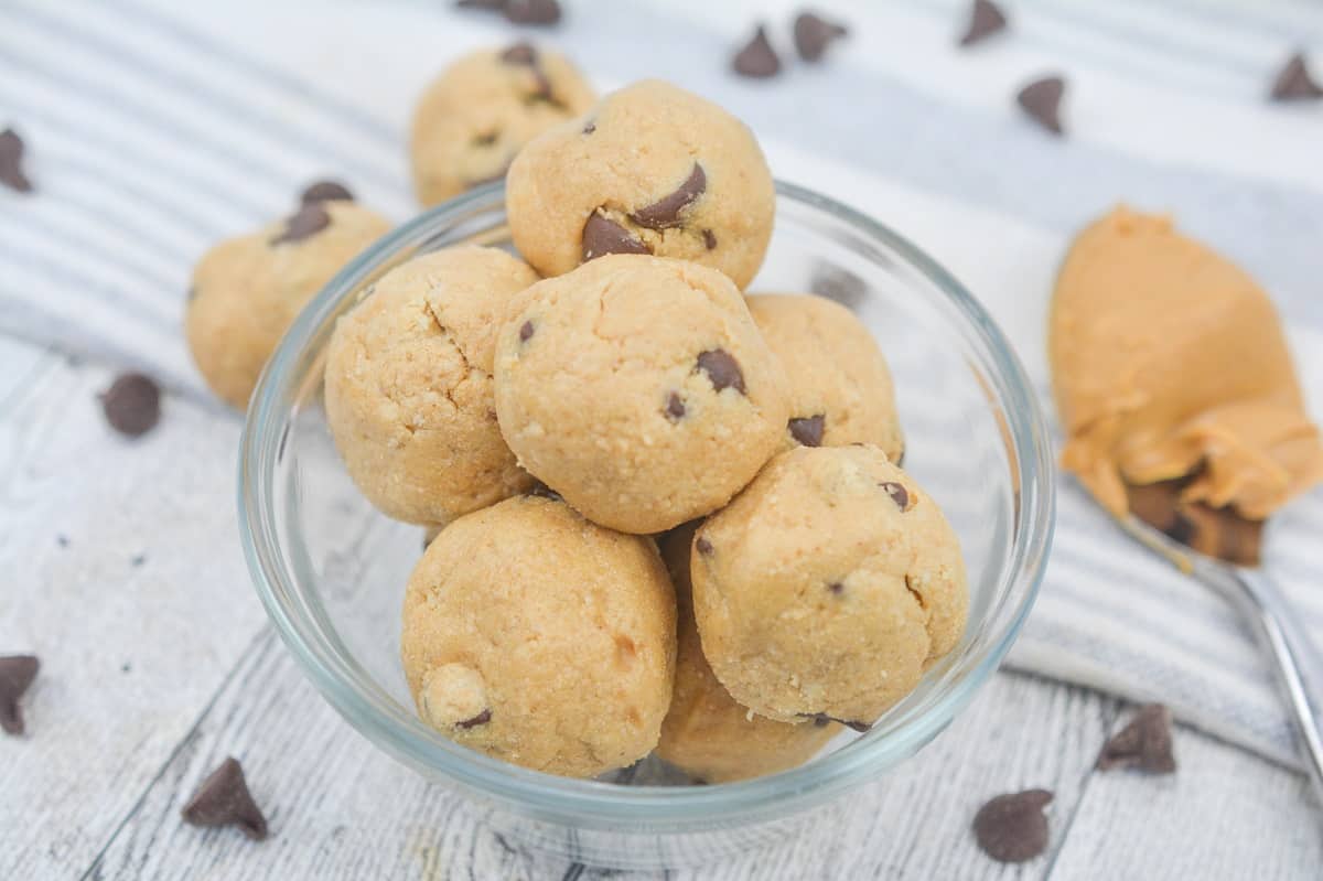Chocolate chip and peanut butter protein balls in a glass bowl.