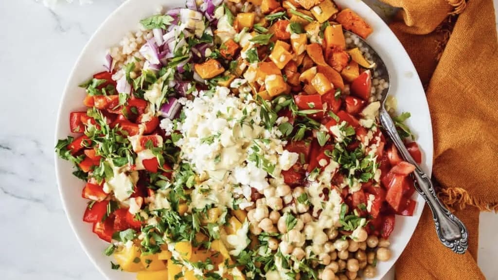 A white bowl filled with a variety of vegetables and chickpeas, perfect for holiday appetizers.