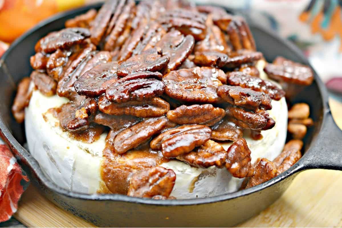 A skillet filled with pecans and cheese.