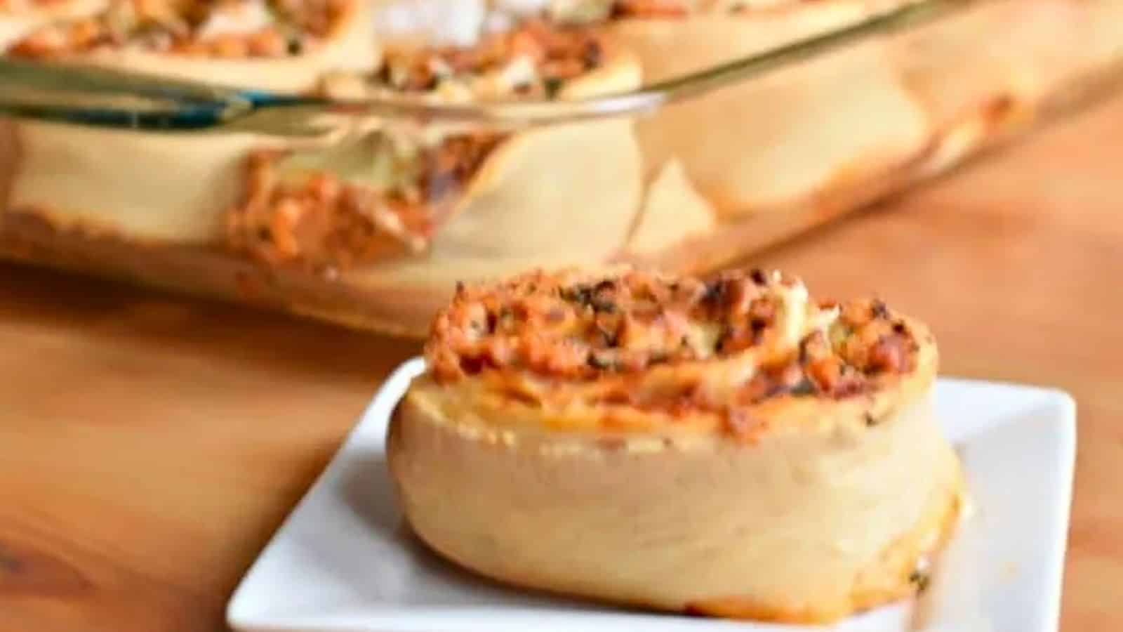 Image shows a Pizza roll on a white plate in front of a pyrex with the rest of the batch in it.