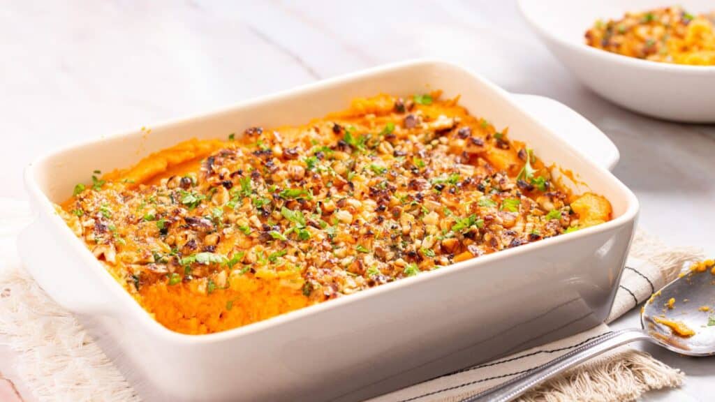 A dish of sweet potato casserole with a spoon.