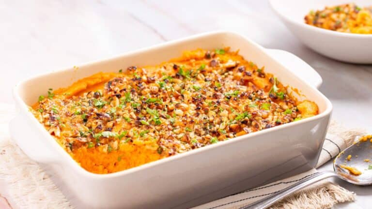 A dish of sweet potato casserole with a spoon.